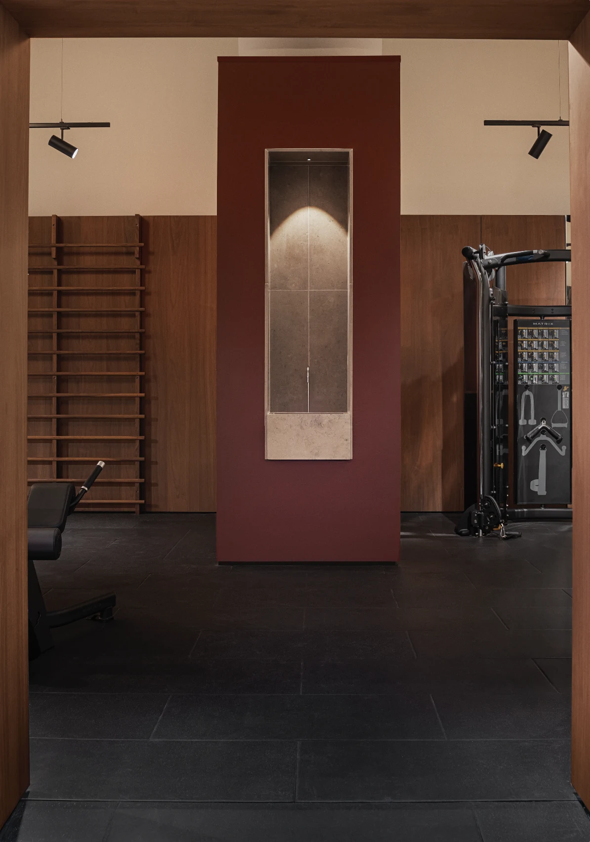 Deep red panel with a full-length mirror beside the training rig