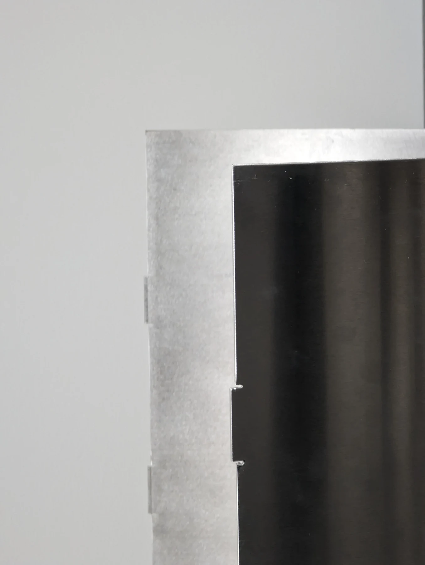 Detail of the sheet edge where the brushed surface meets the rolled curve