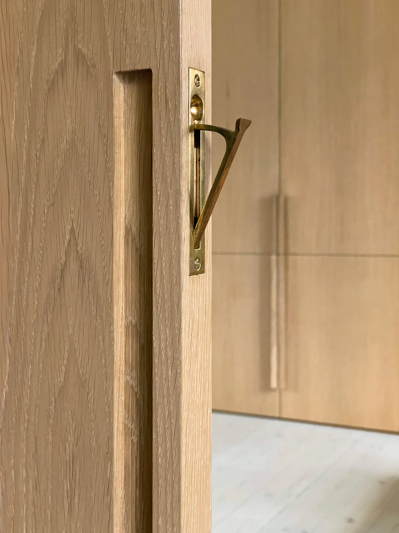 Oak door detail with a slender brass handle